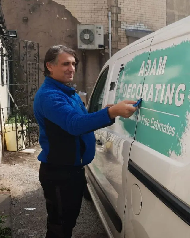 Fitting cut vinyl lettering to the side of a van by hand