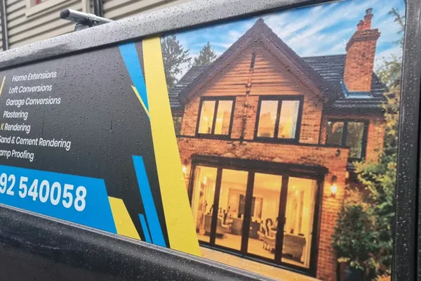 Side window graphics: services list, phone number and a large photo of a finished brick house