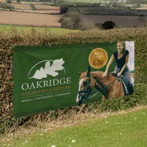 2m x 0.5m PVC Banner: printed equestrian centre banner on a hedge
